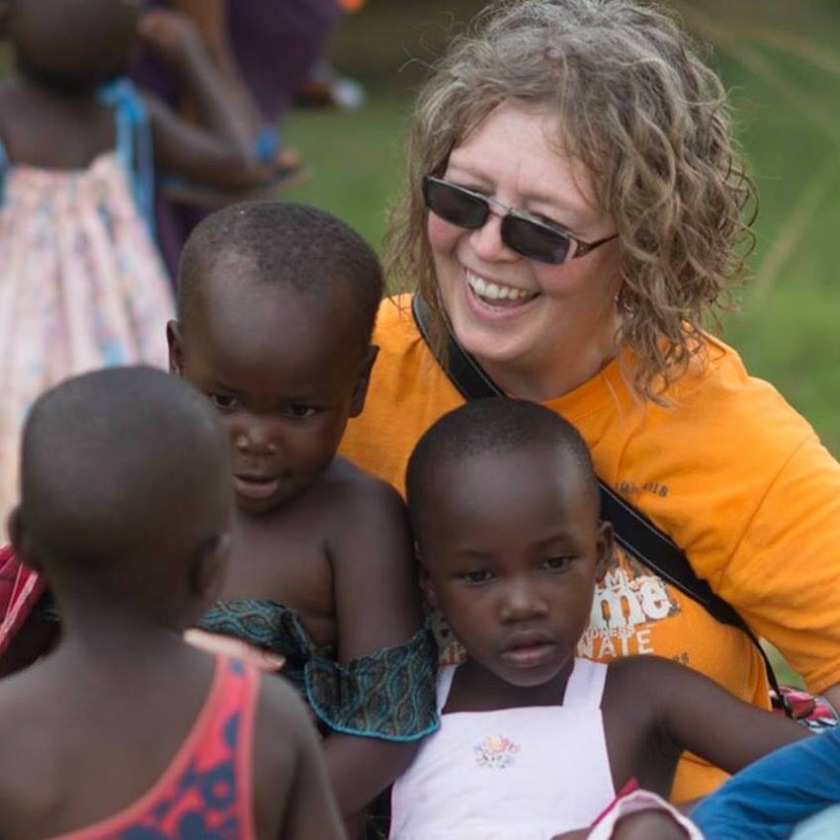 Cheryl in Uganda with beautiful orphans. Photo by Mike Kelly, PhotoEmagery